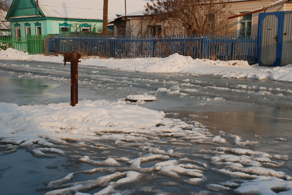 Вода заковала в лед улицу Актюбинскую. Жители привыкают выкидывать урожай из погребов 
